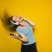 Wildes Tanzen zu lauter Musik kann eine tolle Energiequelle sein. Auf dem Bild: Singende, tanzende Person vor gelbem Hintergrund.